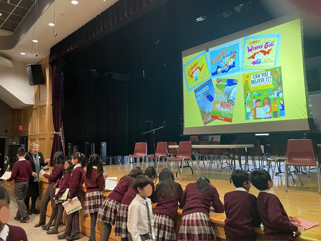 Joyce Grant signing autographs for grade 5 students