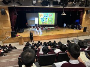 Joyce Grant presenting to grade 5s in an auditorium