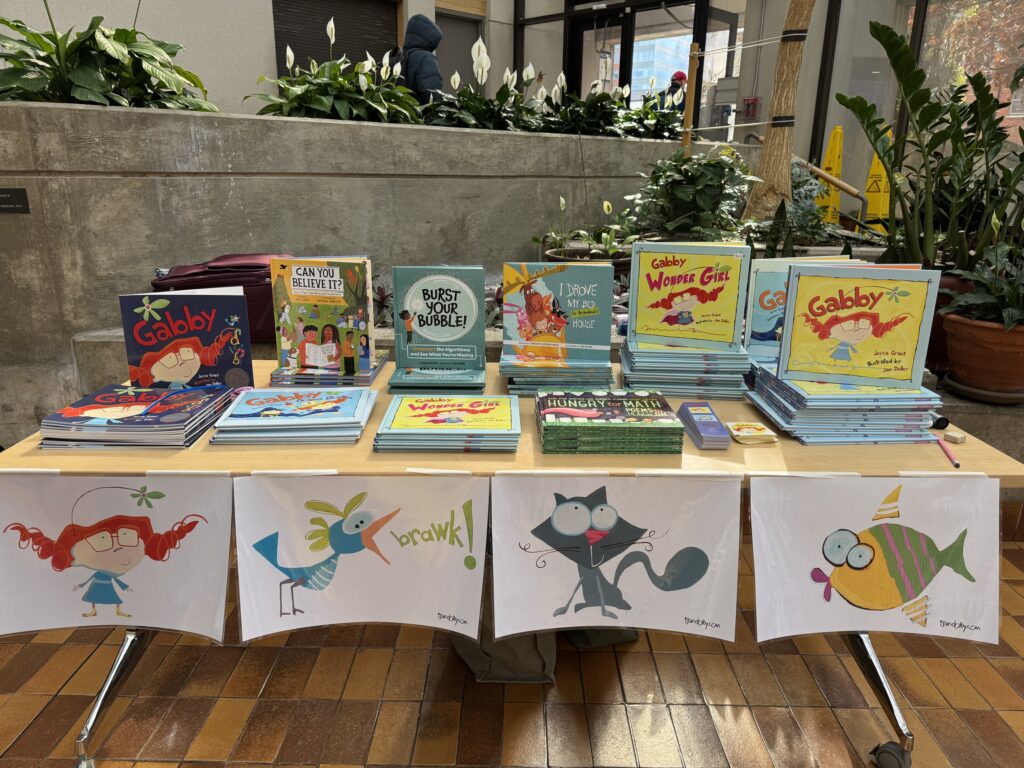a table is covered with books including Gabby, Gabby: wonder girl and Gabby: drama queen as well as Can You Believe it? and Burst your Bubble and I drove my Bed to Gramma's House